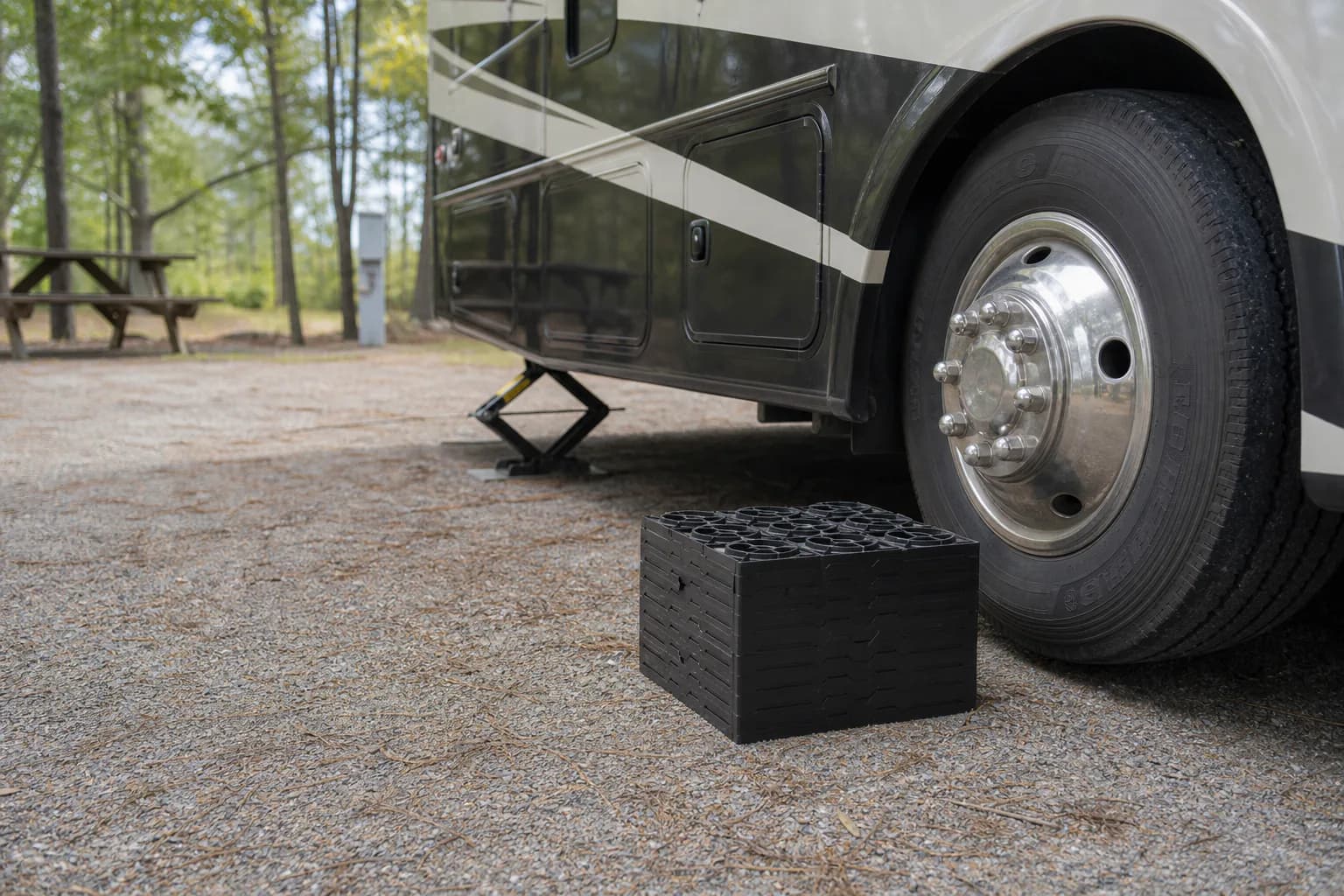 Stackable leveling blocks placed near an RV tire at a campsite